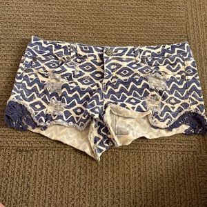 Used Aztec pattern shorts with distressed design.